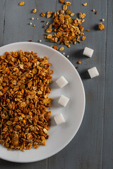 Granola in a bowl and sugar cubes. Added sugar in products.