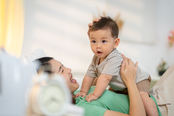 Asian baby and woman doing lifestyle activities together at home.