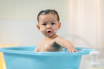 Asian baby taking a bath at home