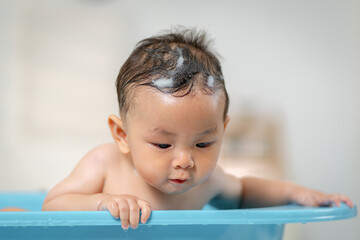 Asian baby taking a bath at home