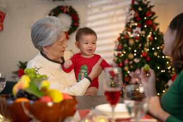 Asian baby and family celebrating Christmas together at home.