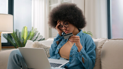 African American woman sad girl frustrated with insufficient funds problems payment online credit bank card trouble failure internet shopping bankruptcy use laptop try pay blocked scam fraud at home