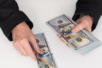 Woman hands holding pile of 100 US dollar banknotes