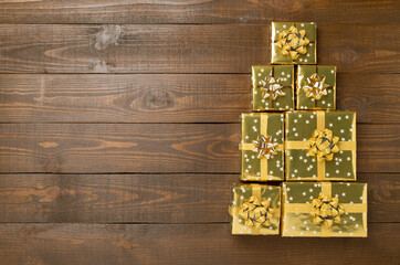 Obraz premium Gift boxes in Christmas tree shape on wooden background, top view