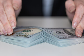 Woman hands holding pile of 100 US dollar banknotes