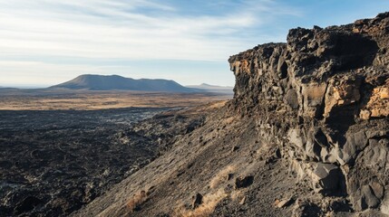 Obraz premium Volcanic Landscape with a Rugged Cliff and Distant Craters