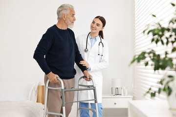 Doctor helping senior man with walking frame in clinic