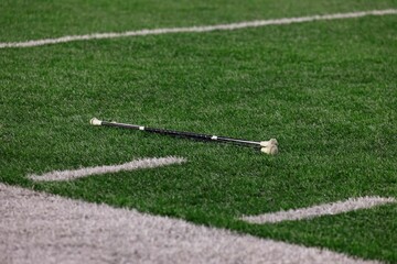Close-up of a majorette baton lying on a football field