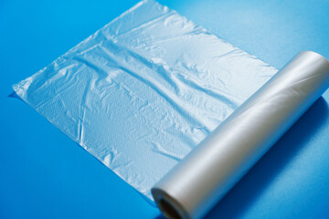 Fototapeta premium Roll of transparent packaging bags on a blue background. storage and packaging of products at home.