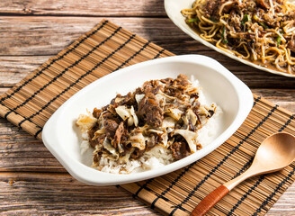 Beef and black pepper risotto with spoon served in dish isolated on wooden table side view of taiwan food