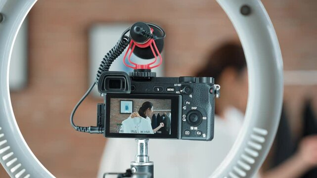 Rear view behide camera screen display woman influencer shoot vlog video review clothes prim social media or blog. Girl with apparel studio lighting for vivancy live streaming marketing recording