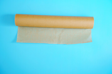 A roll of baking paper on a blue background. tools for baking at home.