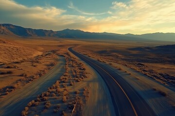 Fototapeta premium Desert road winding through rugged landscape at sunset in Nevada