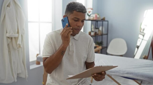 Man talking phone clinic hospital indoors reading clipboard physio therapy young workplace rehab latin person