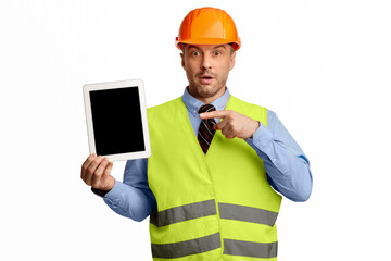 Surprised Worker Man Showing Tablet Empty Screen Advertising Building Services Standing On White Studio Background. Look Here. Mockup