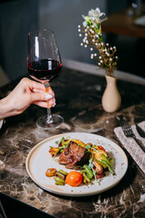Elegant dinner with a gourmet steak and wine, creating a perfect moment of indulgence and style