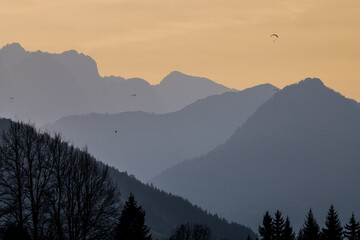 Obraz premium Paragliders silhouetted over the mountains in Reit Im Winkl, Germany.