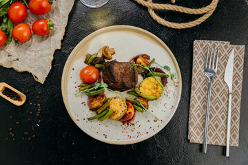 Grilled beef steak with vegetables and herbs, served with wine in a rustic presentation