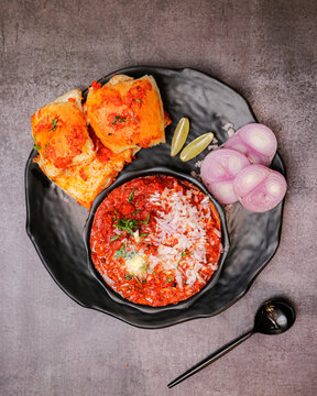 Black ceramic plate filled with Indian Pav Bhaji