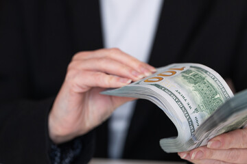 Woman hands holding pile of 100 US dollar banknotes