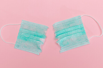 Anti Mask Movement - Green Torn Medical Face Mask on the Pink Background. Pandemic and Lockdown End...