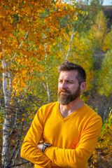 Autumn portrait of a man on a background of yellow autumn