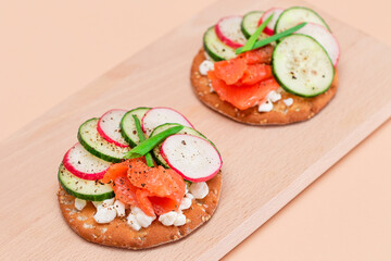 Crispy Cracker Sandwiches with Fresh Salmon, Cucumber, Radish, Cottage Cheese and Green Onions. Easy Breakfast. Quick and Healthy Sandwiches. Crispbread with Tasty Filling. Healthy Dietary Snack