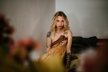 Naklejka premium Artistic Portrait of a Woman with Tattooed Shoulders in Soft Light