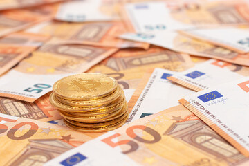 A Stack of Bitcoin Coins on the 50 Euro Banknotes. Euro Currency and Crypto Currency. Orange Paper Money. A Lot of Fifty-Euro Bills. Finances, Cash, Anonymous Payments and Money Saving Concept