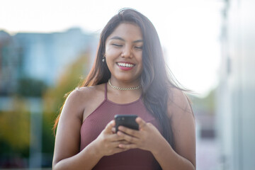 Smiling woman using a smartphone outdoors