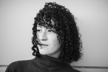 Black and white portrait of woman with curly hair looking away