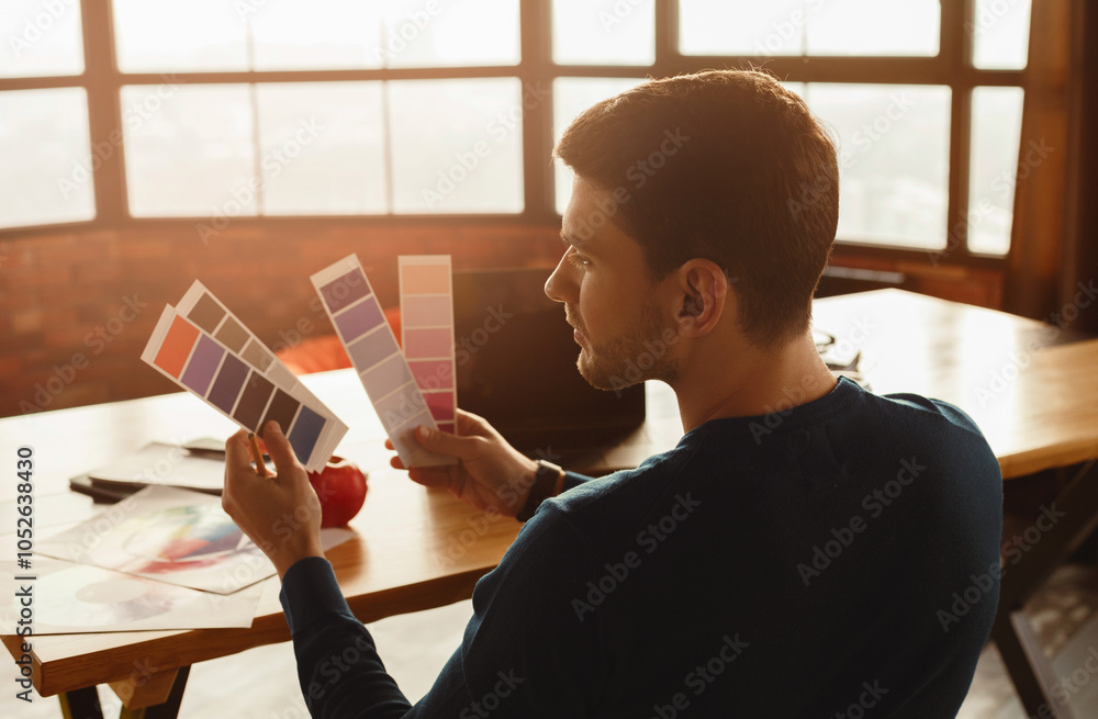 Aufkleber young man choosing color using palettes and samples designing website working sitting in modern offi