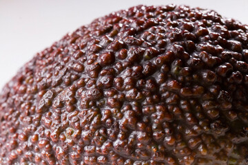 An avocado fruit with a stone taken in close-up on a white background. avocado fruit texture