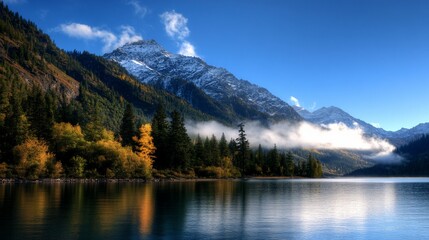 Obraz premium A serene lake with a snowy mountain peak and forest in the background.