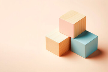 Obraz premium Pastel wooden cubes on a light background. Space for text.