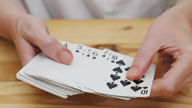 Women's hands check, look through the claude of playing cards. gambling. A board game for spending leisure time with friends and family.
