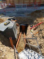 Access and egress steps in excavation trench with installed drainage pipes and waterproofing...