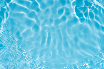 Blue water with ripples on the surface. Defocus blurred transparent blue colored clear calm water surface texture with splashes and bubbles. Water waves with shining pattern texture background.