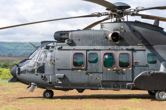 Black painted modern H225M military transport helicopter stationary on the ground