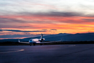 Airplane at sunset - back lit. Airplane waiting for its schedule at the airport