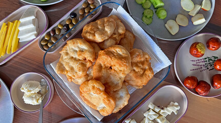 A Turkish breakfast table with pişi, made by frying dough, and various breakfast foods.
