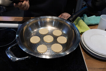 Frying mini pancake cereal in a nonstick frying pan.
