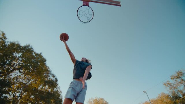 Young sportsmen engage in playing basketball throwing ball on court