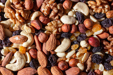Mixed Nuts: Almonds, Walnuts, Cashews, Peanuts, Hazelnuts, Dried Prunes and Raisins. Different Nut Mix. Background from Various Nuts and Dried Fruits