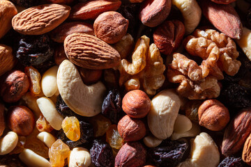 Mixed Nuts: Almonds, Walnuts, Cashews, Peanuts, Hazelnuts, Dried Prunes and Raisins. Different Nut Mix. Background from Various Nuts and Dried Fruits