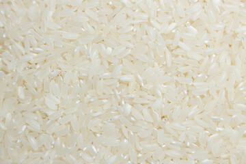 Dry Uncooked White Rice Background - Top View, Flat Lay. Scattered Raw Long Grain Rice. Asian Cuisine and Culture. Healthy Eating Ingredients. Diet Food