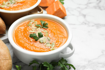Delicious sweet potato soup with fresh ingredients on white marble table, closeup. Space for text