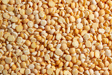 Uncooked Polished Split Peas Background. A Culinary Canvas of Dry Yellow Peas, Creating a Lively and Textured Background for Gourmet Cooking. Scattered Raw Polished Peas. Healthy Eating Ingredients