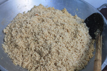 The filling for a traditional Indonesian food called lemper in a wok is made from chicken that is chopped and seasoned

