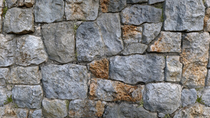 Obraz premium Textured stone wall with irregular dark gray stones